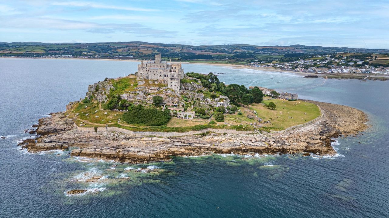 Het kasteeleiland St Michael&rsquo;s Mount met de geplaveide dam bij eb in Cornwall